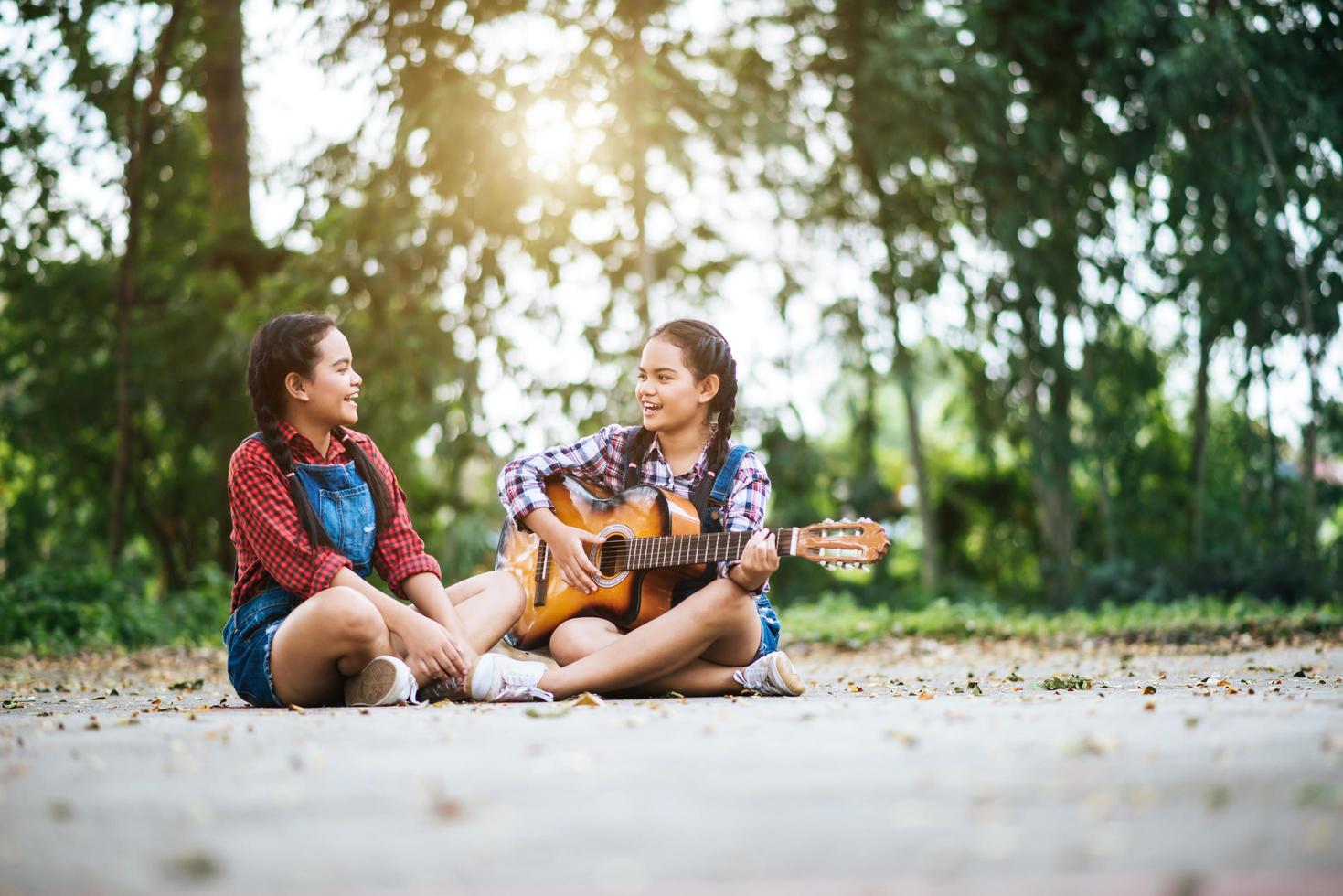 Two girls relaxing and playing guitar photo