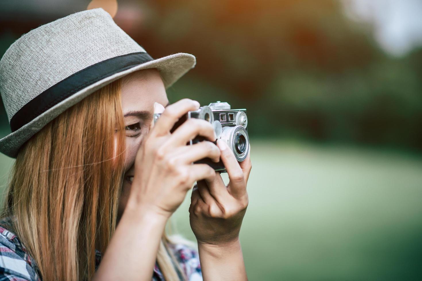 mujer joven posa con cámara de película retro foto