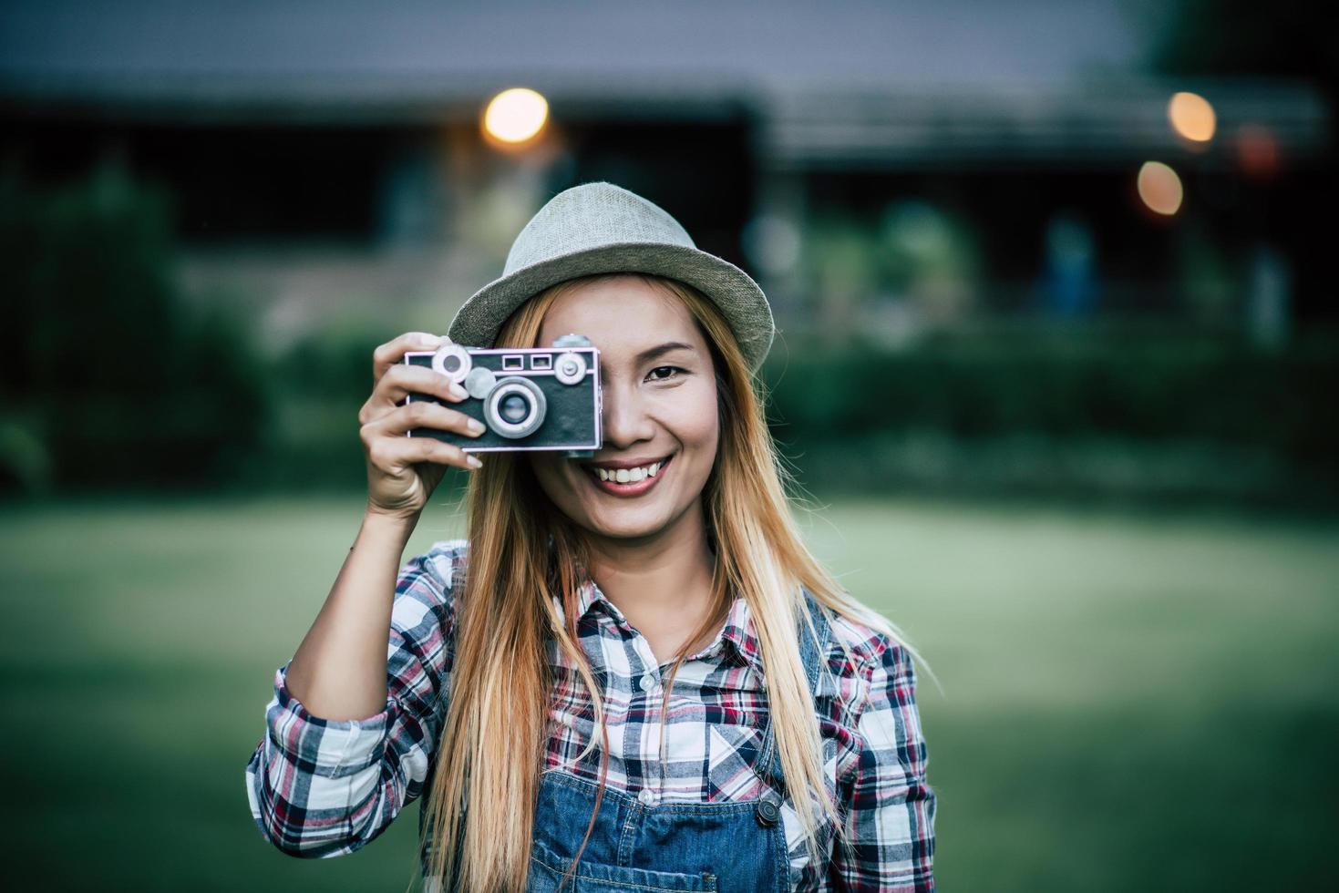 mujer joven posa con cámara de película retro foto