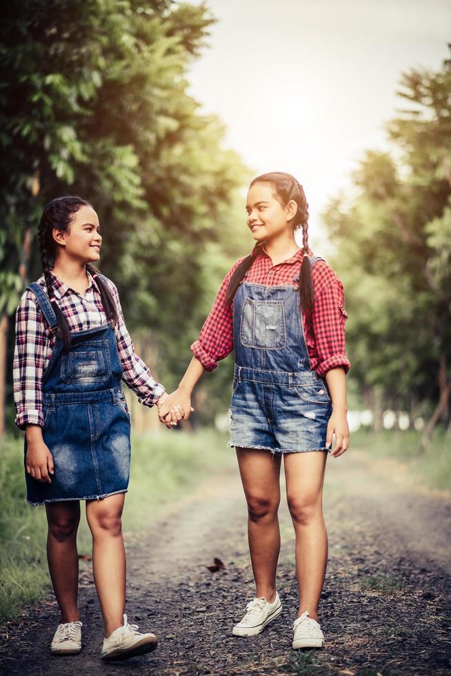 dos niñas caminando por un camino forestal foto