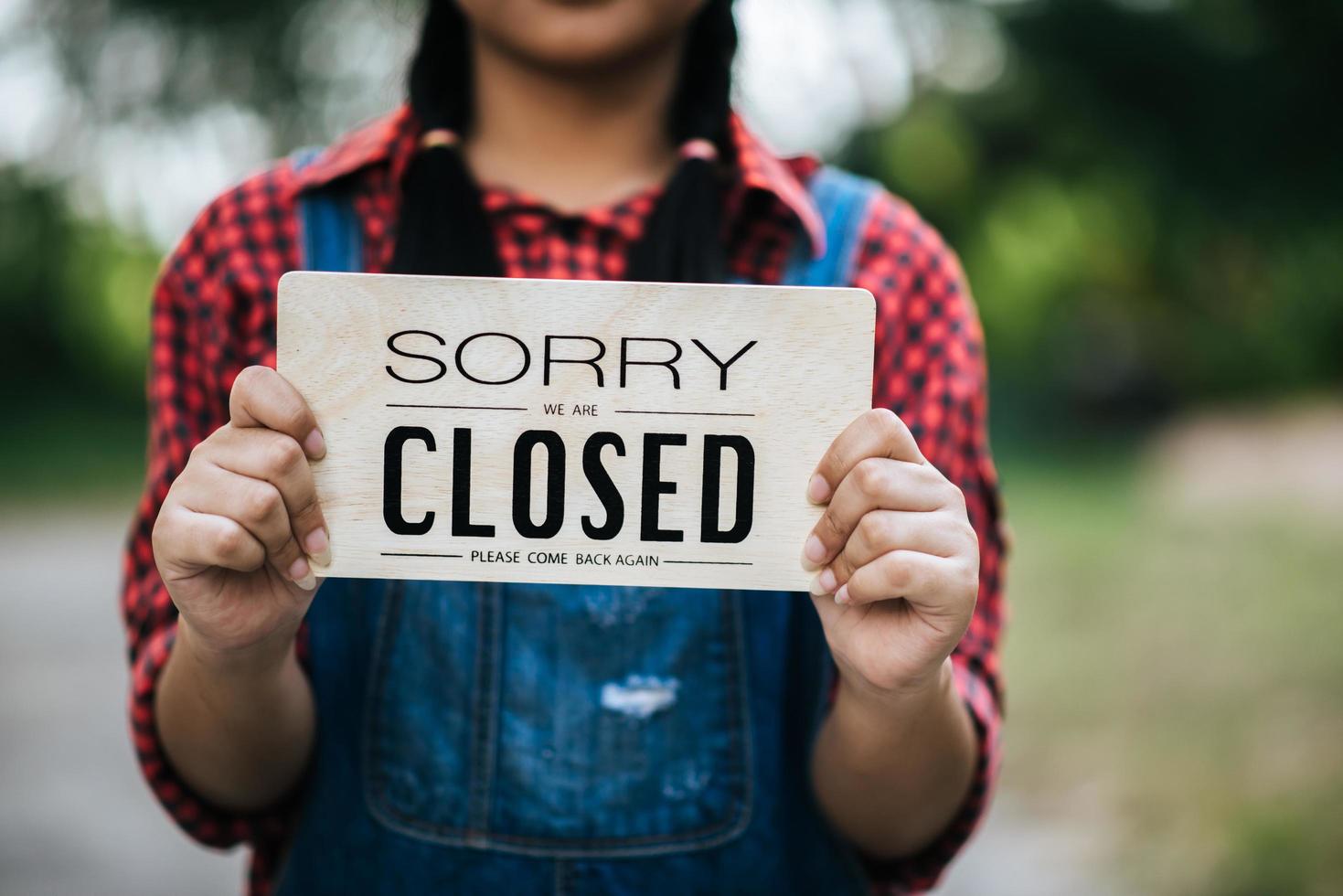 Girl holding a closed sign photo