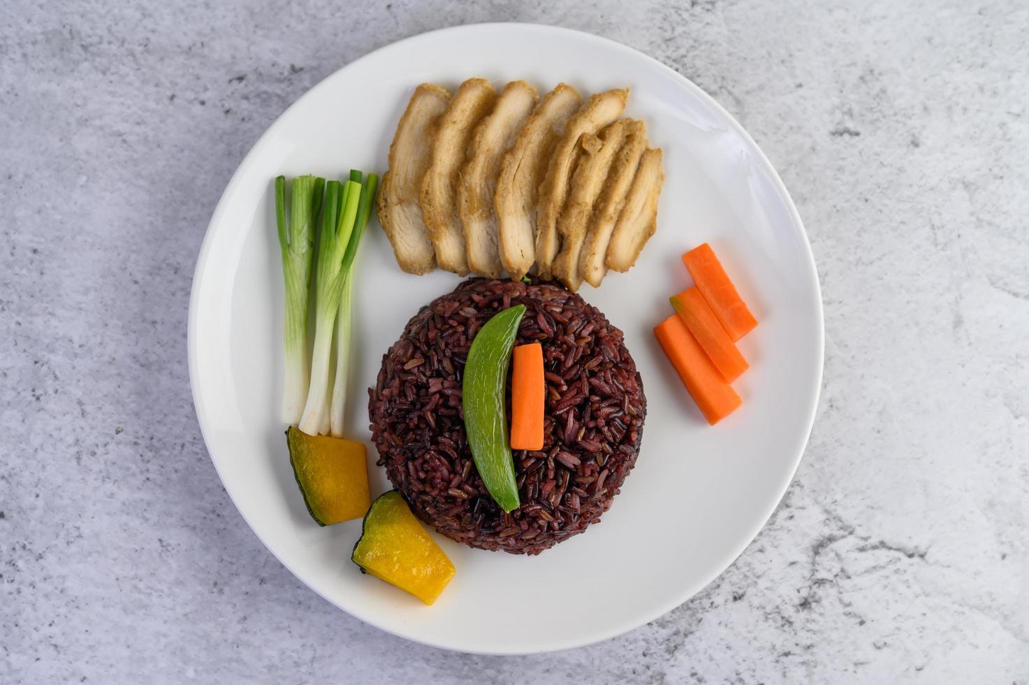 Black rice with pumpkin, peas, carrots, baby corn and steamed chicken breast photo