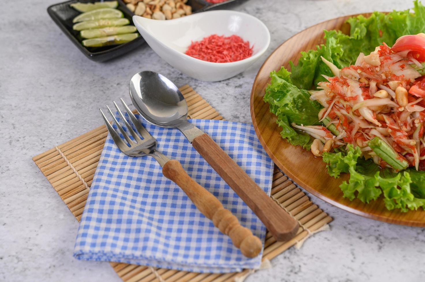 Thai papaya salad with sticky rice, spoon and fork photo