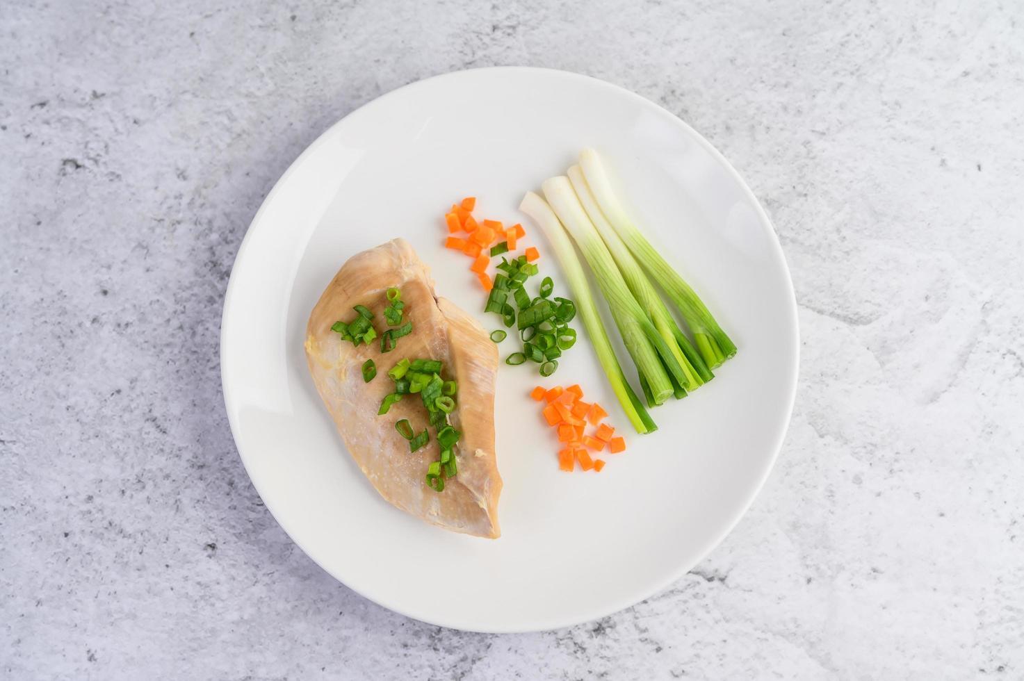 Steamed chicken breast with spring onions and chopped carrots photo