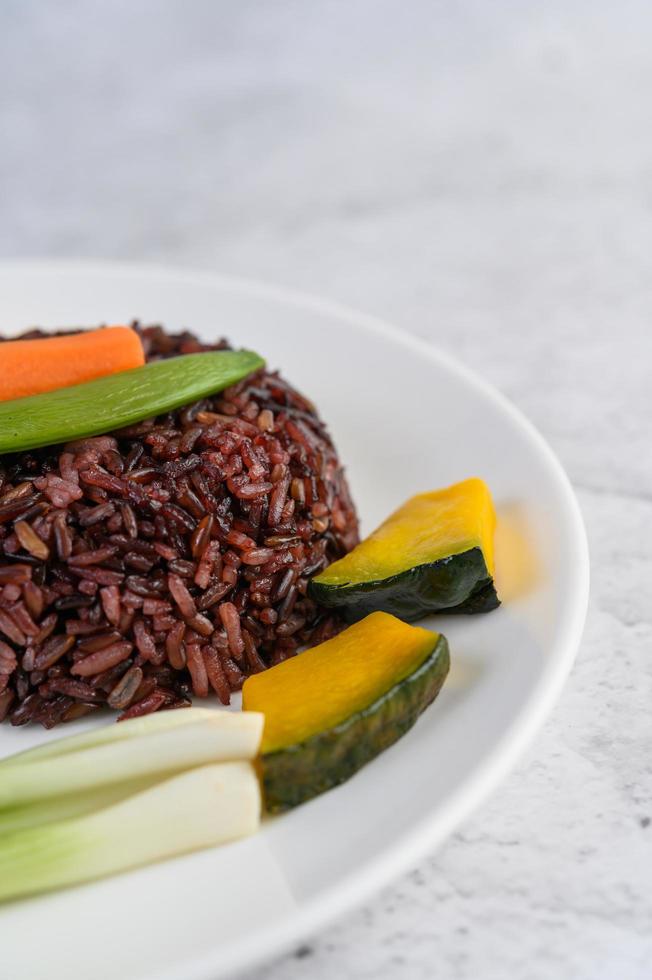 arroz negro con calabaza, guisantes, zanahorias y elote foto