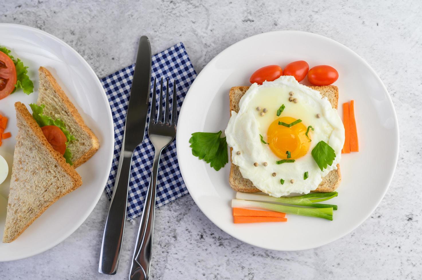 A fried egg on toast topped with pepper seeds with carrots and spring onions photo