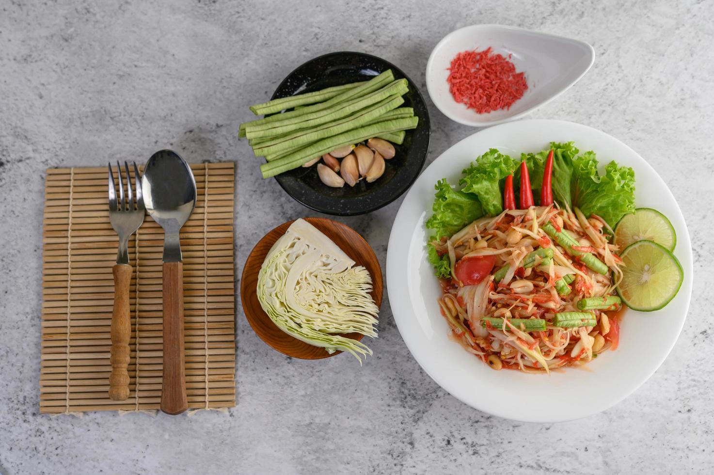 ensalada tailandesa con arroz glutinoso, camarones secos, cuchara y tenedor foto