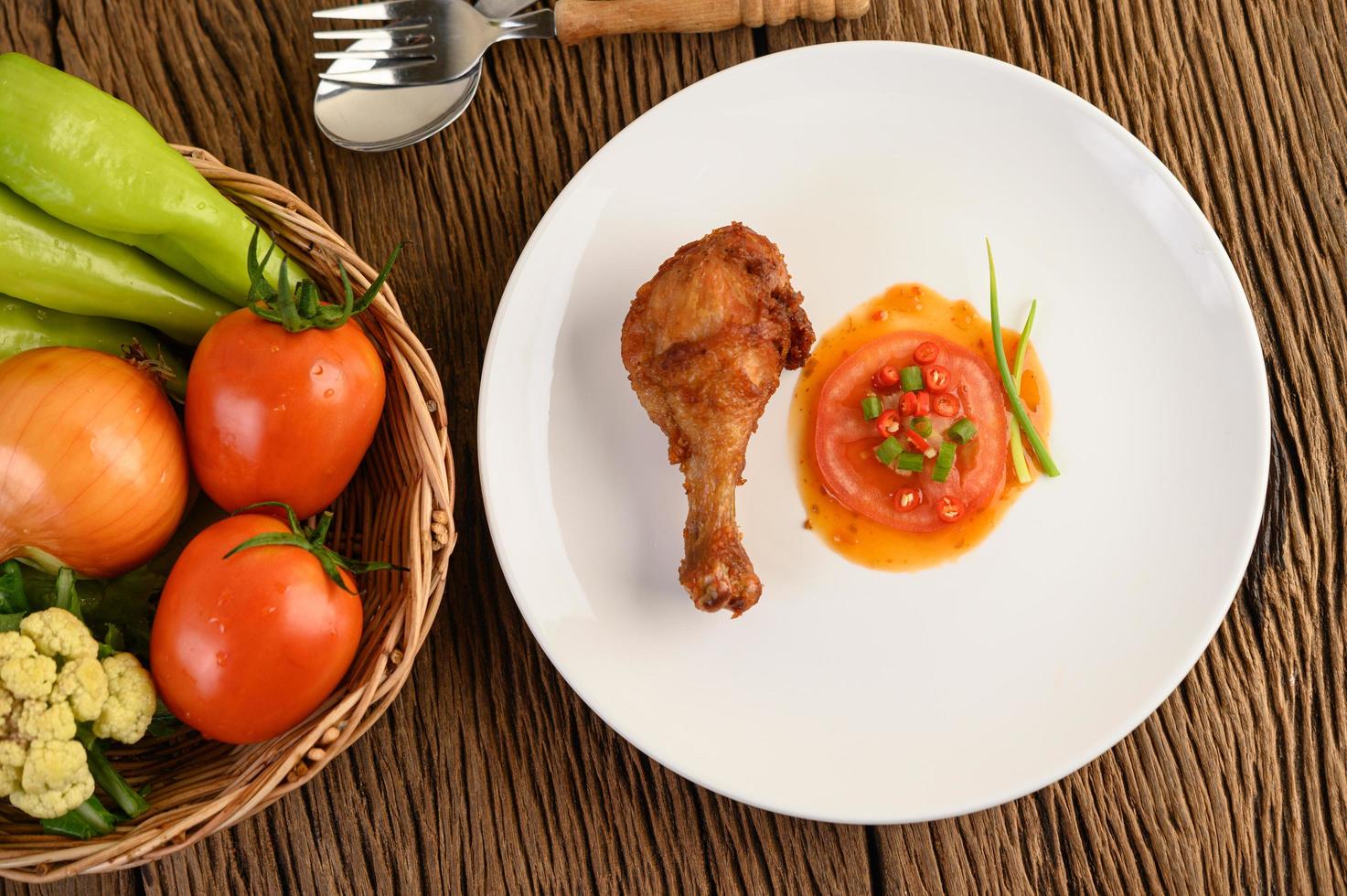 Fried chicken legs with sauce and veggies photo