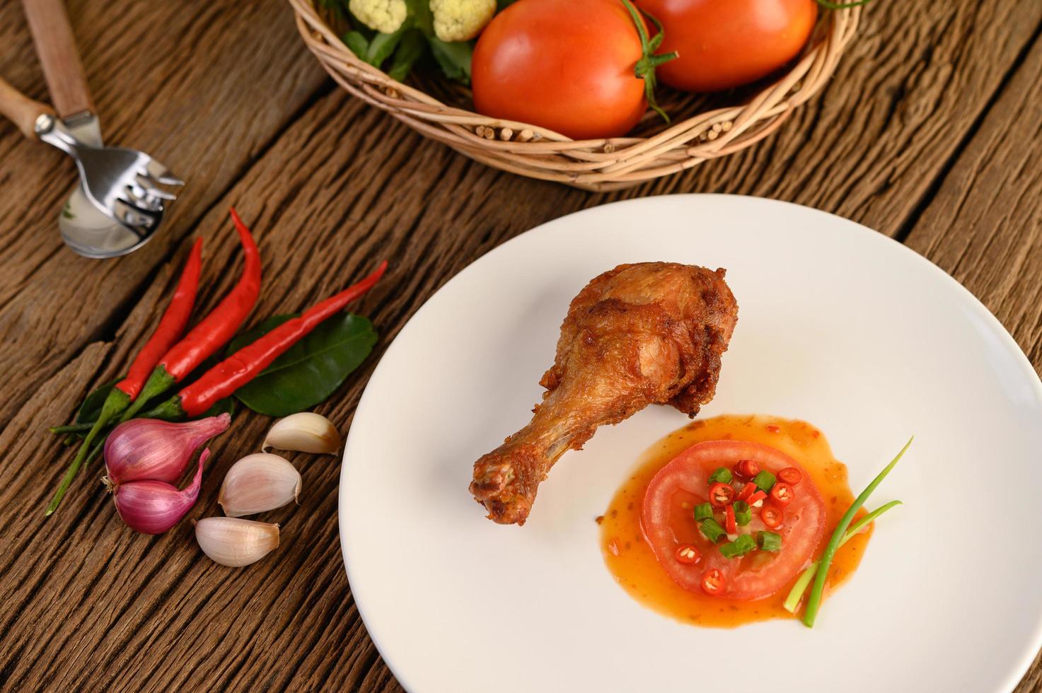 Fried chicken legs with sauce and veggies photo