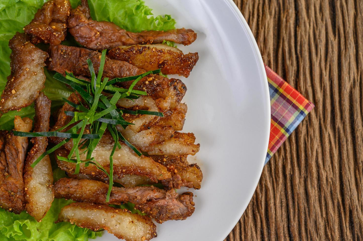 Grilled pork neck on a wooden table photo