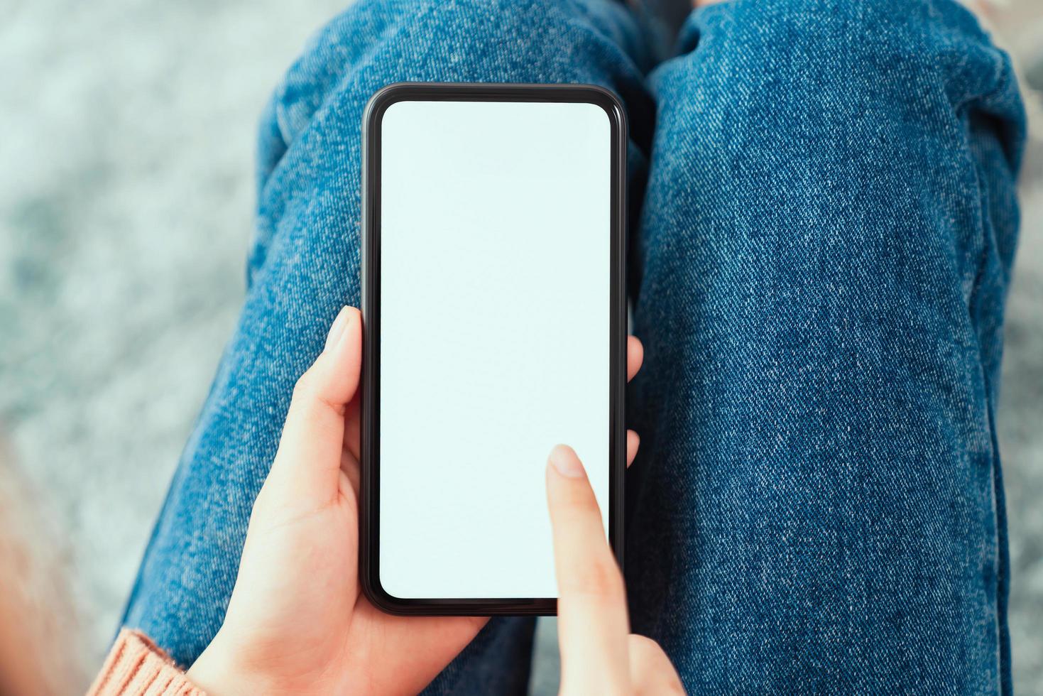 Hand holding smartphone mockup of blank screen on the table photo