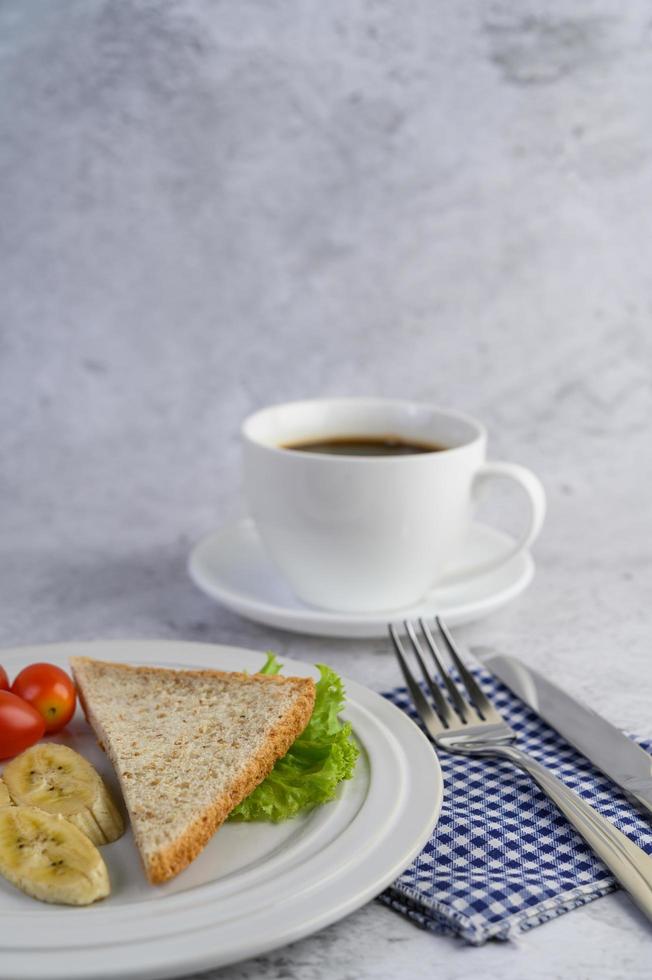 Bread with banana and tomatoes on a white plate photo