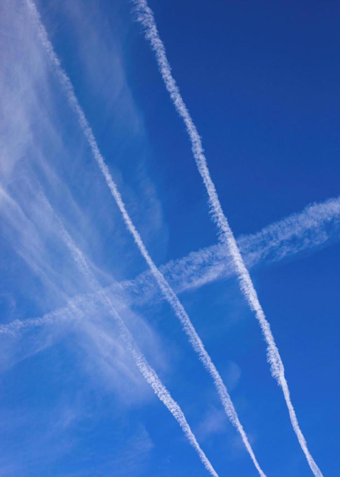 Jet contrails criss-cross on a bright blue fall morning photo