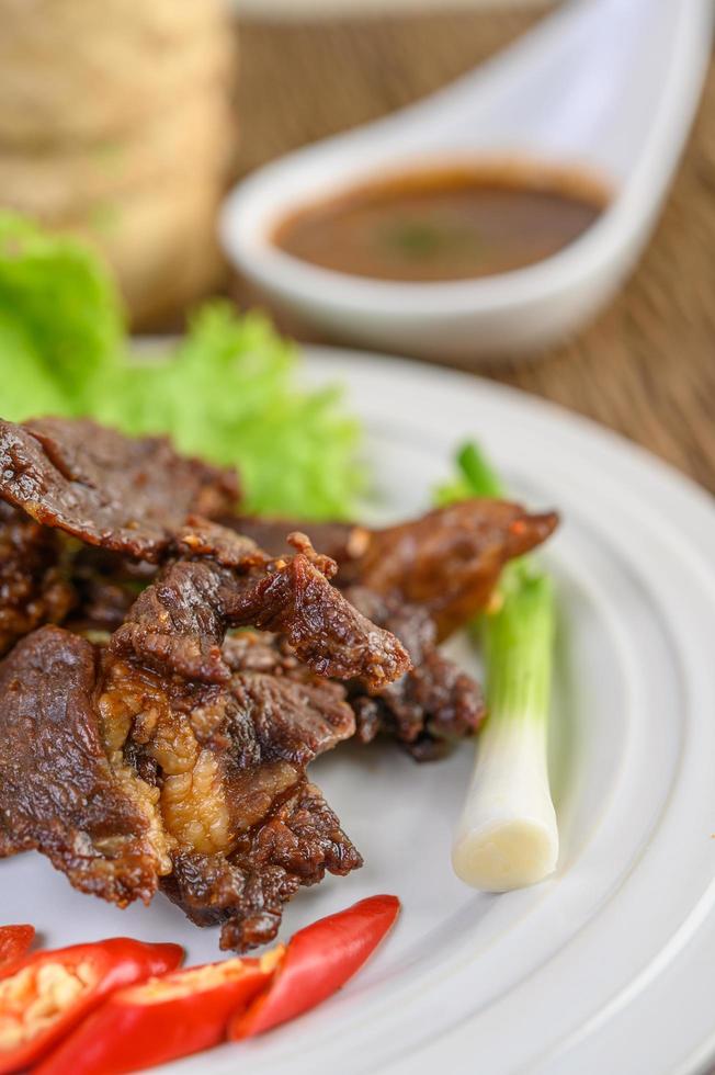 Beef fried Thai food with spring onion, lime, chili and salad photo