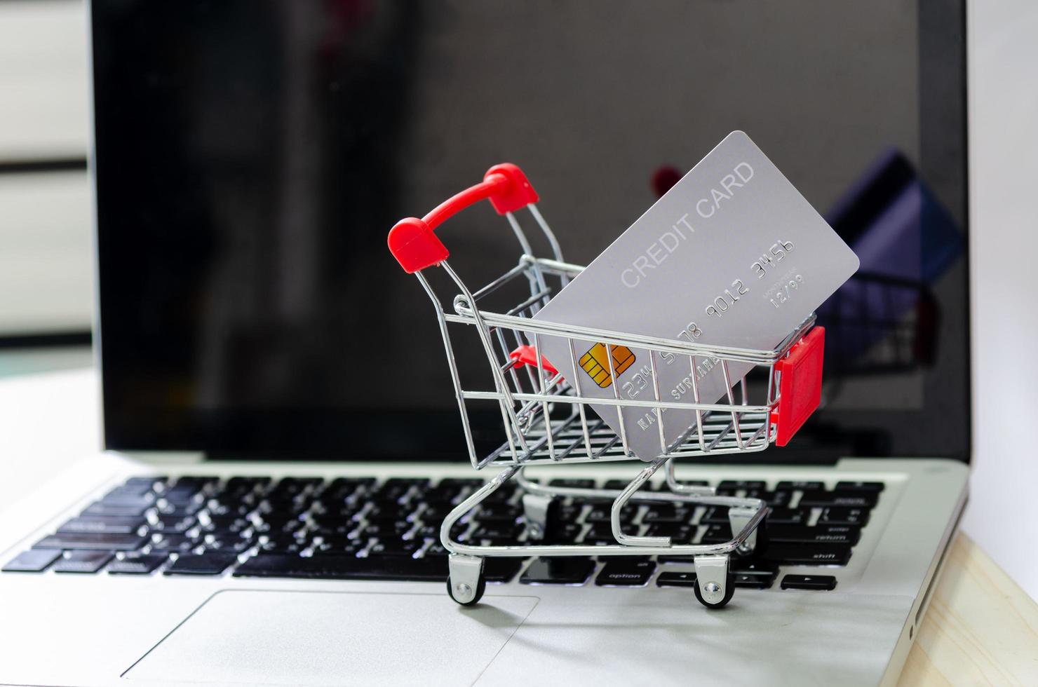 tarjeta de crédito en un pequeño carrito de compras foto