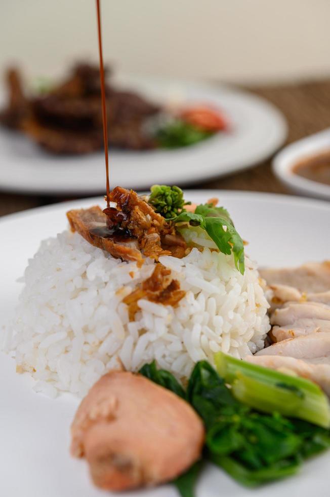 cerdo crujiente sobre arroz blanco cubierto con salsa foto