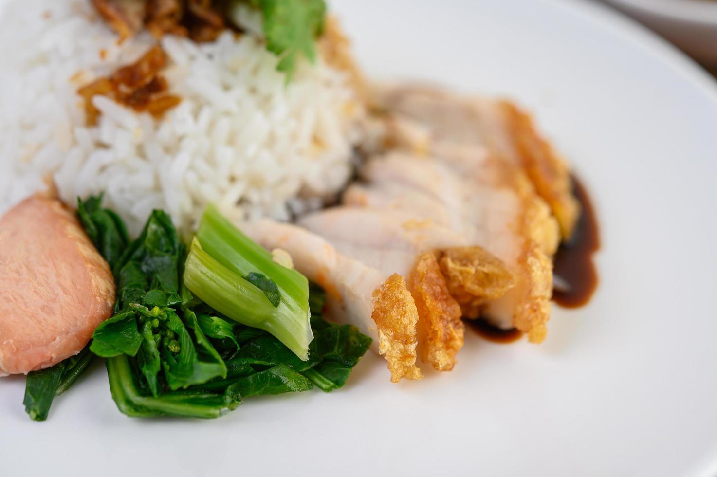 Crispy pork on a white rice topped with sauce photo