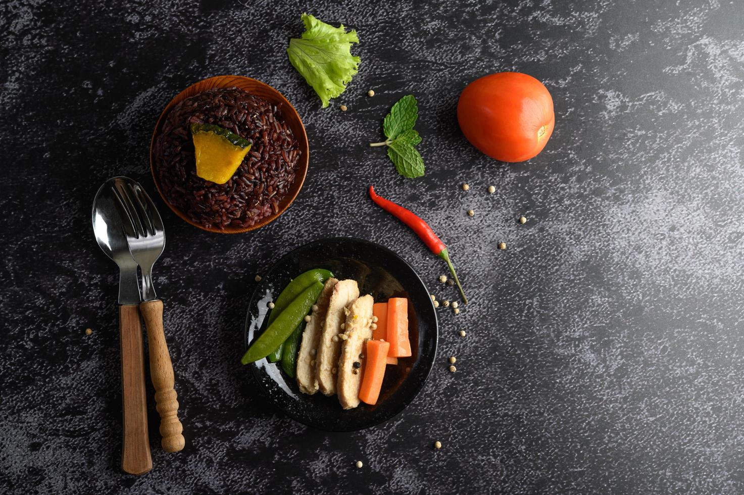 Purple rice berries with grilled chicken breast, pumpkin, carrots and mint photo