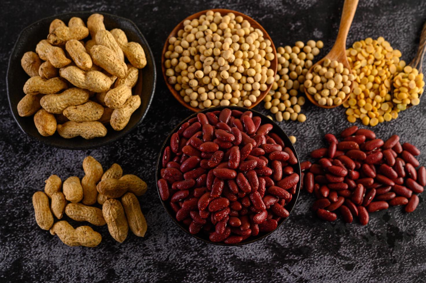 Legumes and beans assorted on a black cement surface photo