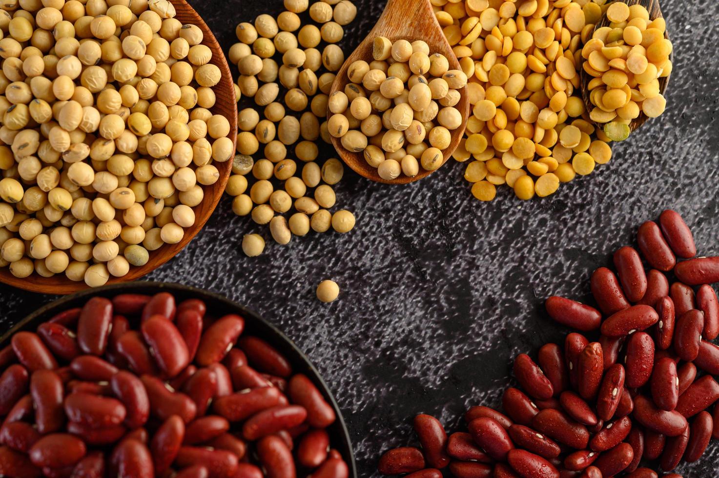 Legumes and beans assorted on a black cement surface photo