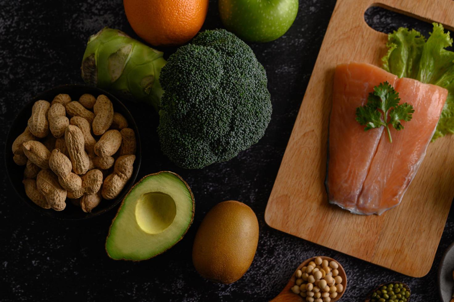 Legumes, fruit and salmon fish on a wooden chopping board photo