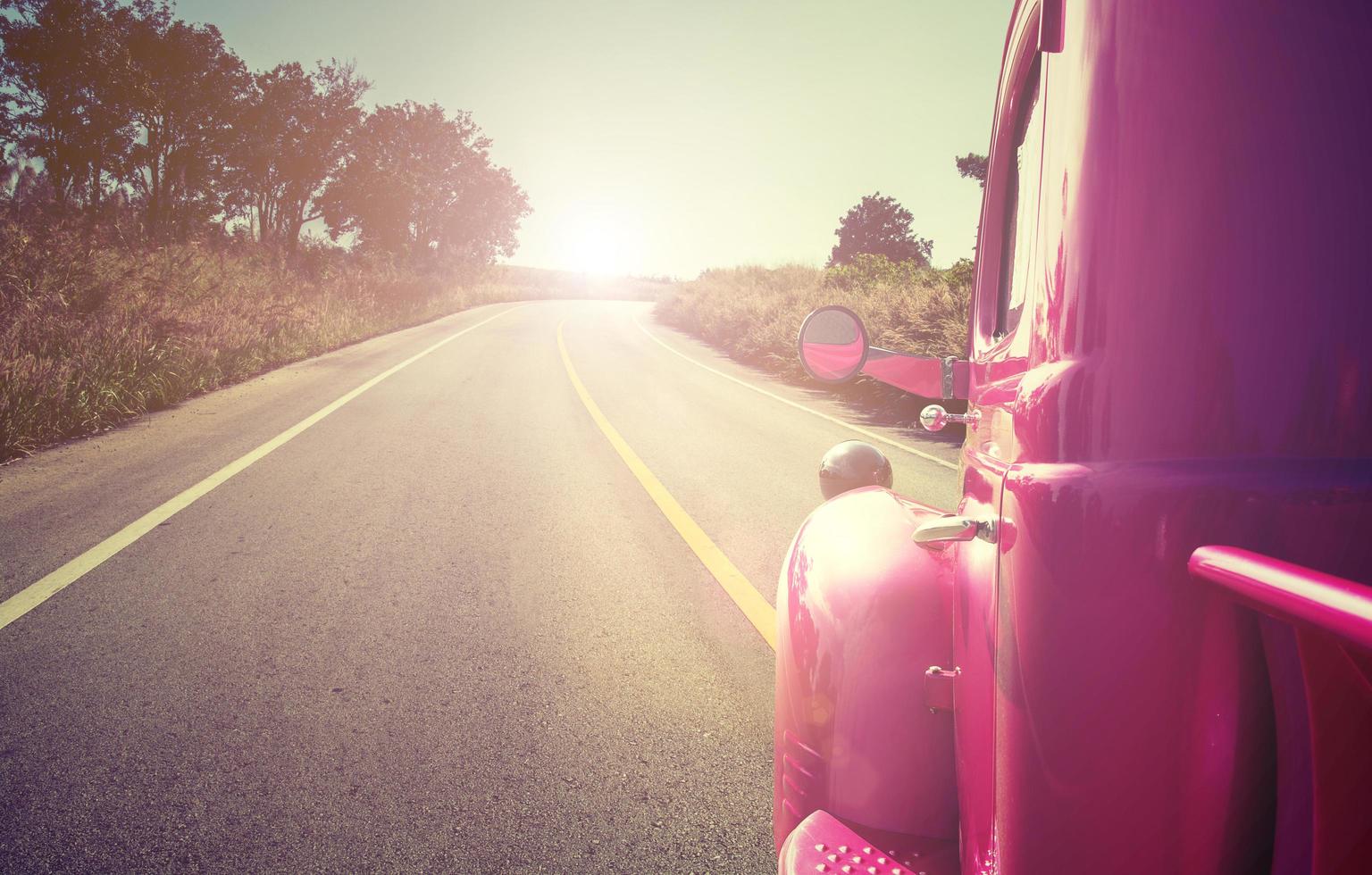 coche retro rosa en la carretera foto