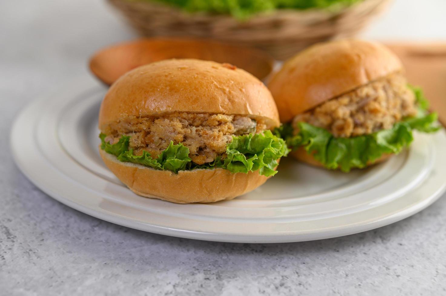 dos hamburguesas colocadas sobre un plato blanco maravillosamente foto