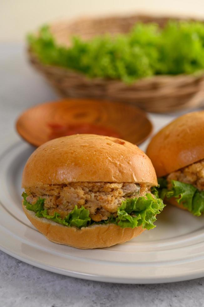 dos hamburguesas colocadas sobre un plato blanco maravillosamente foto