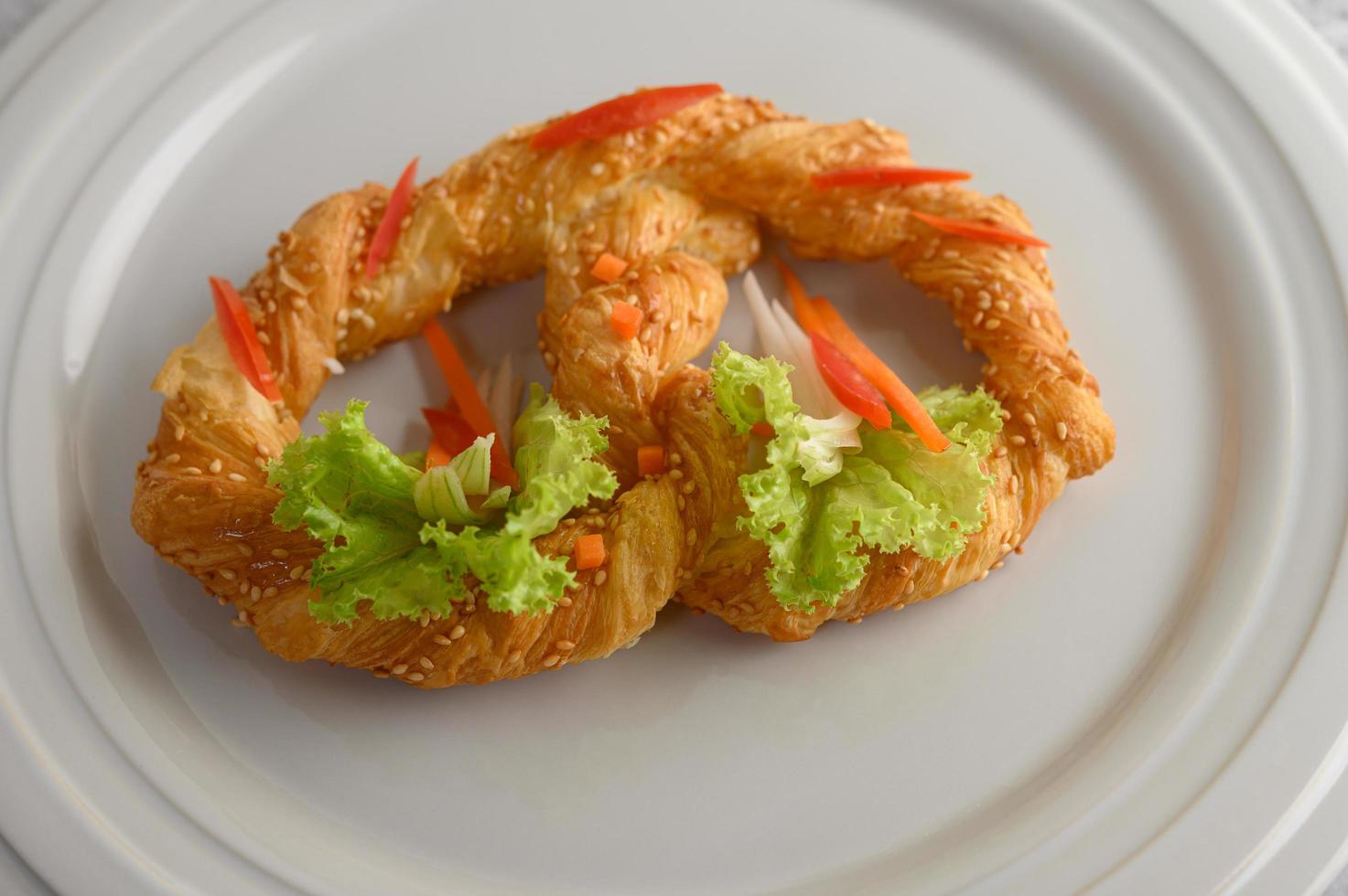 Freshly baked soft pretzel on a white dish photo