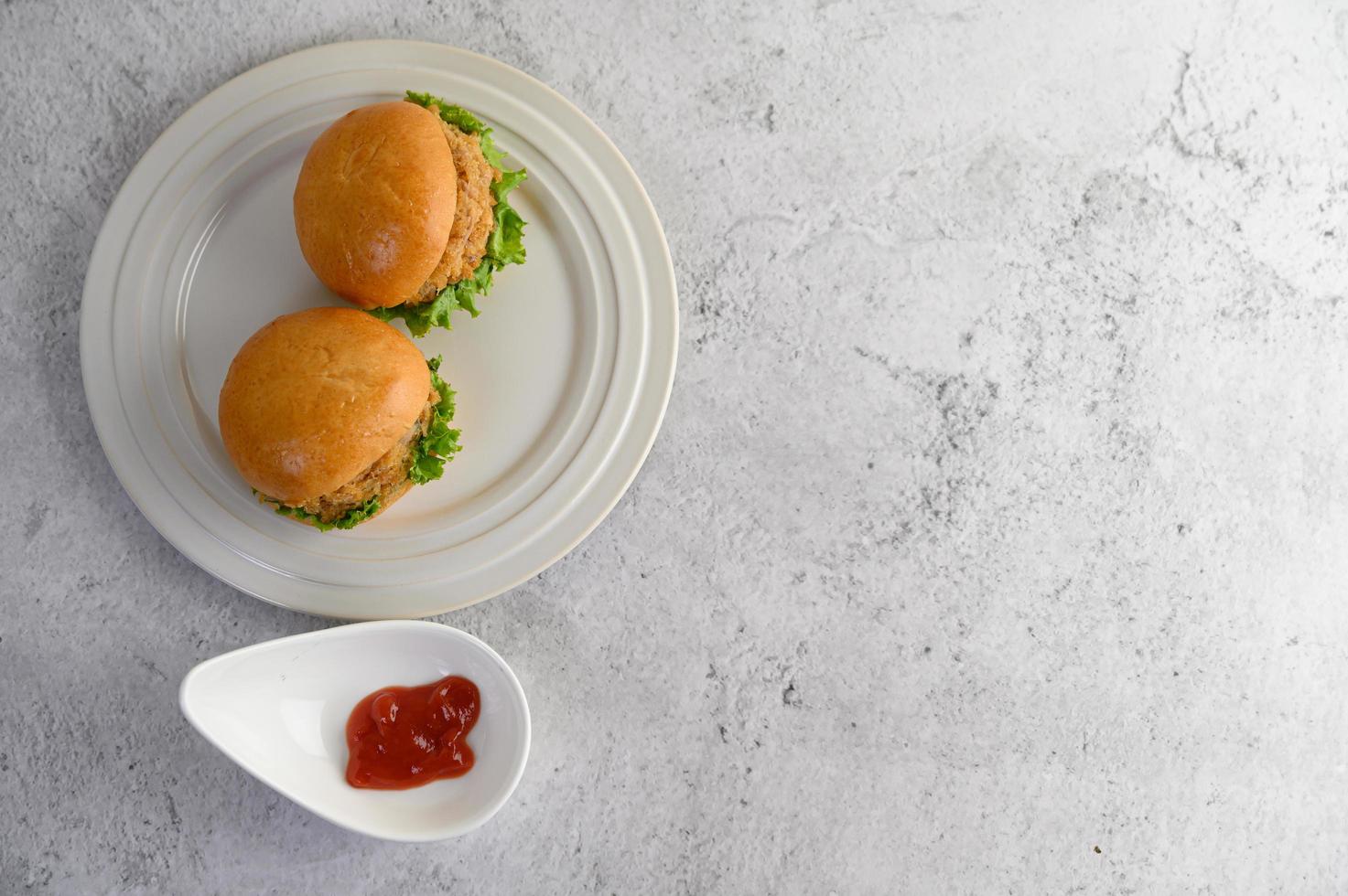 Two hamburgers placed on a white dish beautifully photo