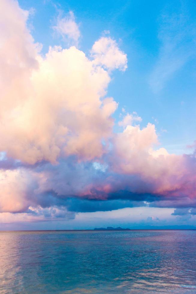 Colorful clouds and blue sky over water photo
