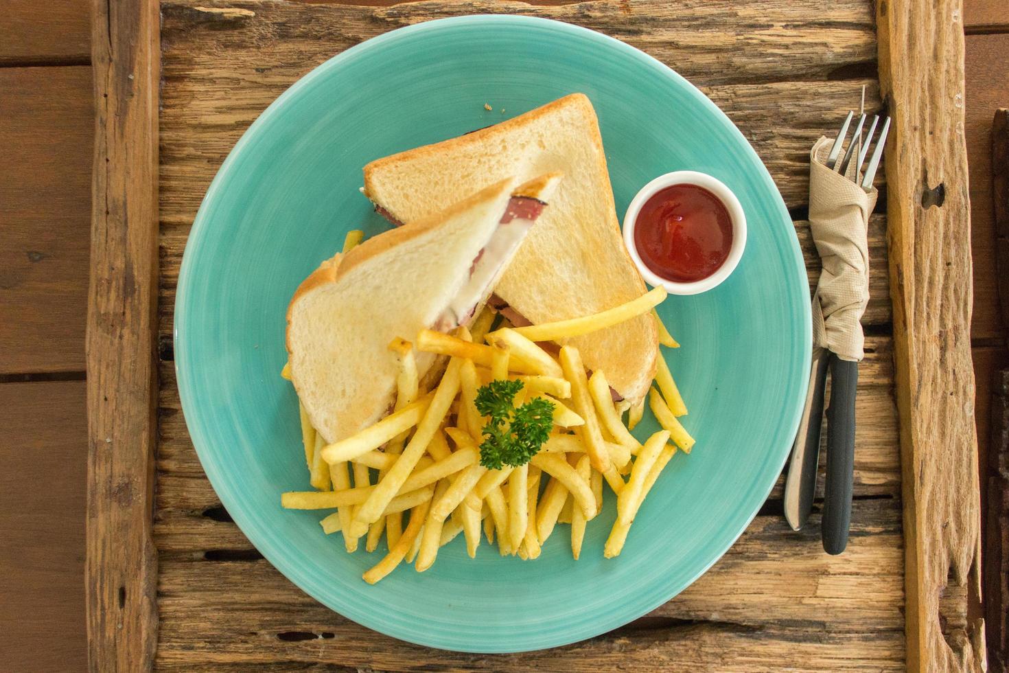 Ham and cheese sandwich with french fries on blue plate photo