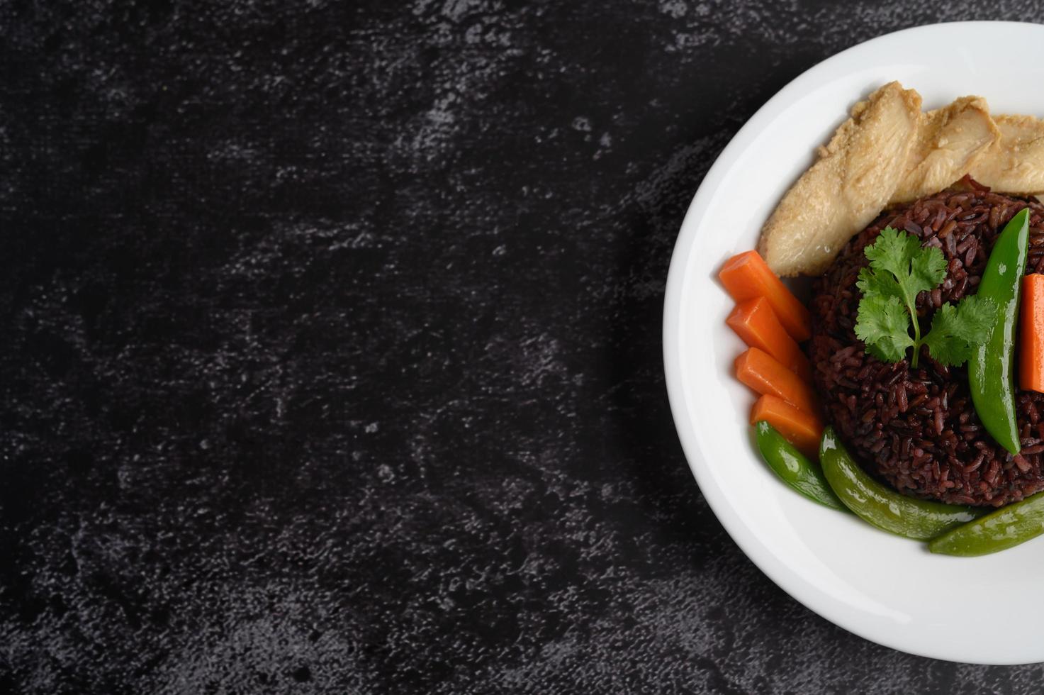 Purple rice berries with grilled chicken breast, pumpkin, carrots and mint leaves photo