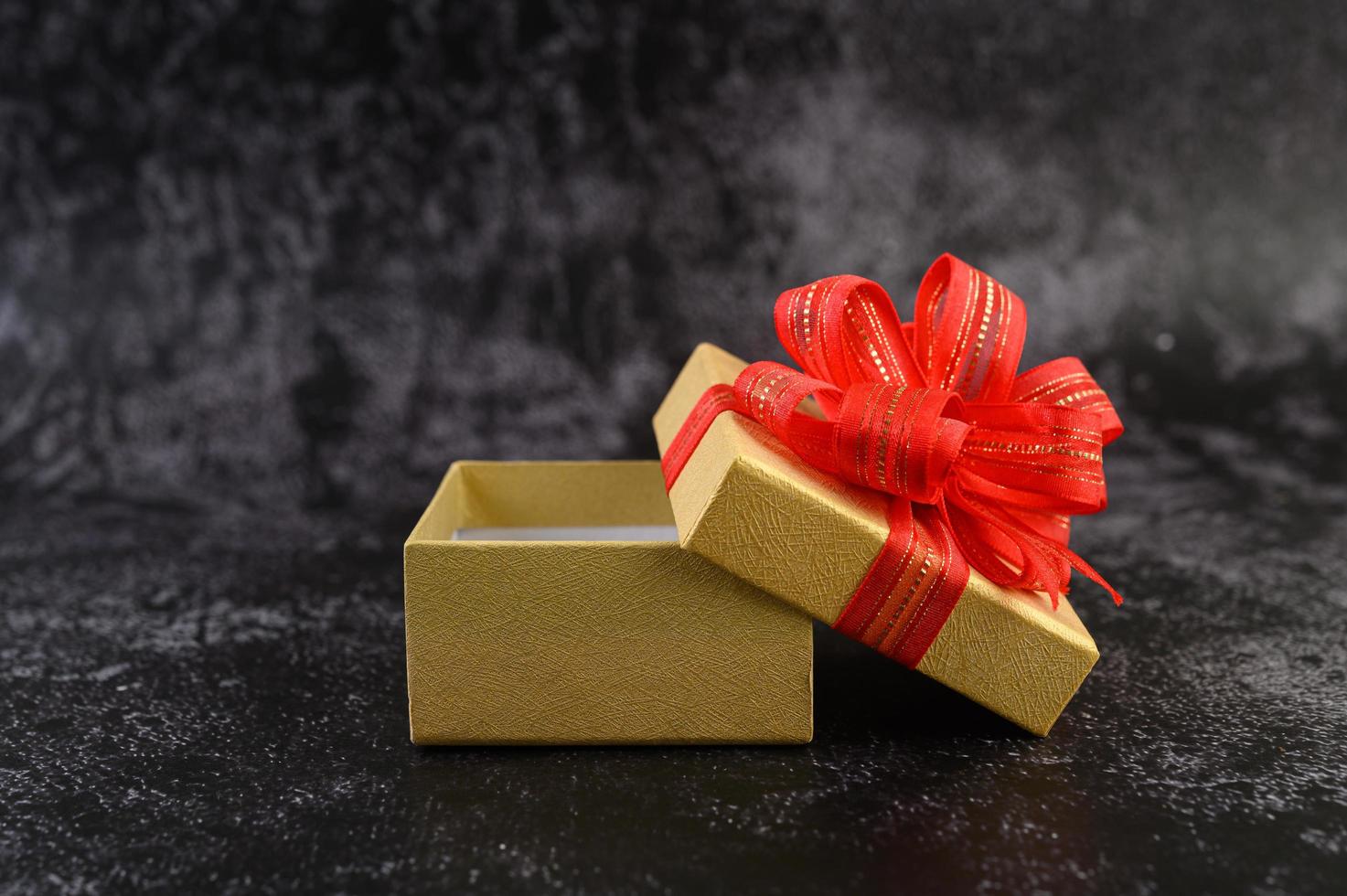 Gift box with a red bow tied and opened photo