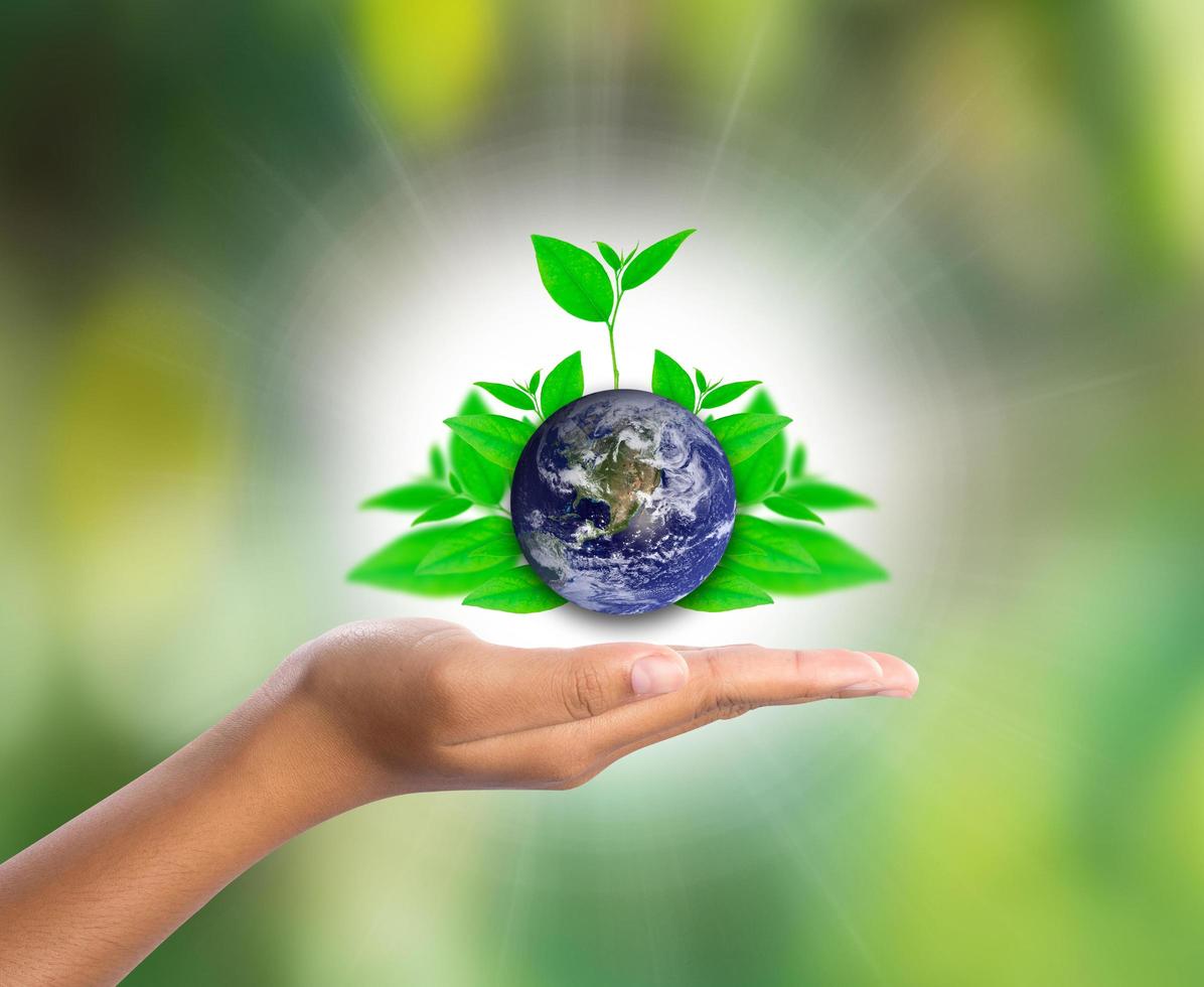 Earth on hand with green leaf, elements of this image furnished by NASA photo