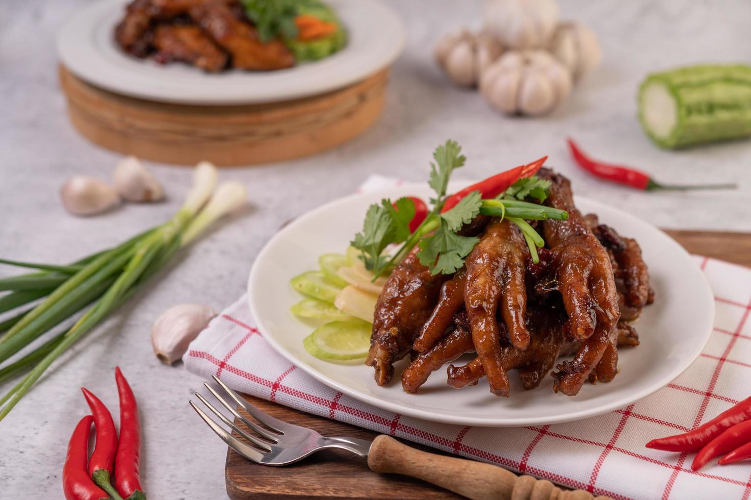 Sweet fried chicken feet with coriander, chili, cucumber and tomato photo