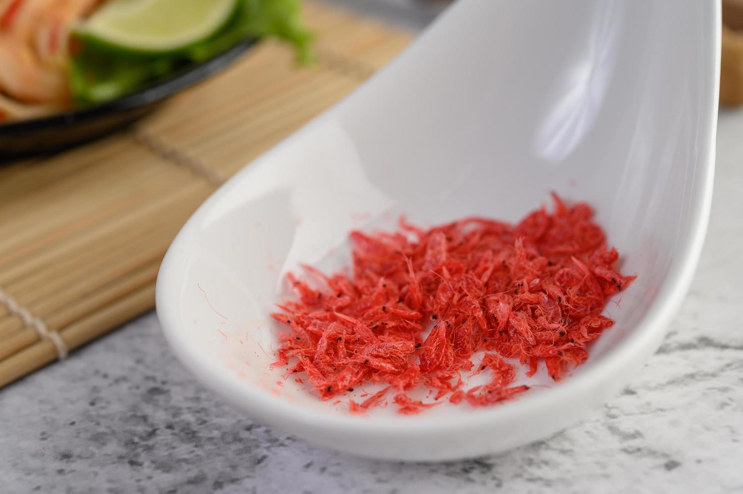 camarones rojos secos pequeños en una taza blanca foto