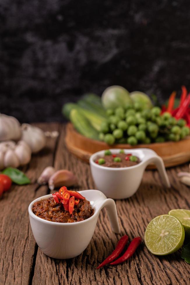 Red eye chili paste with lemon and chili on wooden board photo