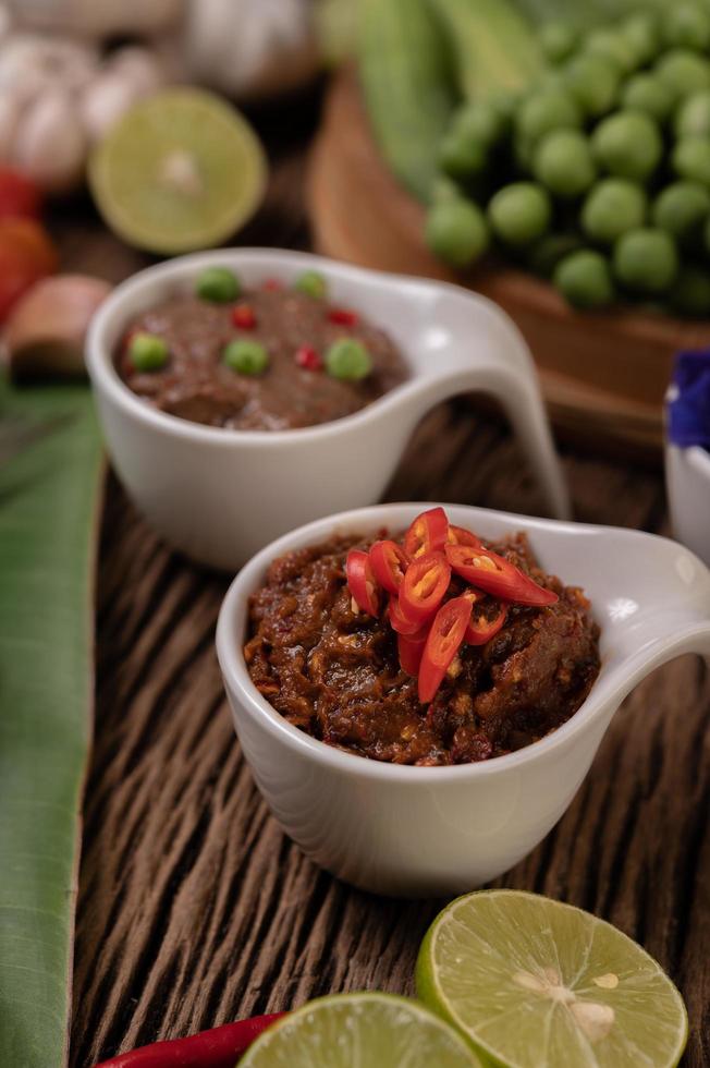 Red eye chili paste with lemon and chili on wooden board photo