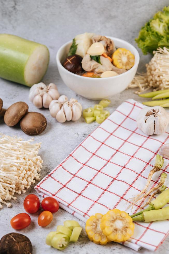 Soup ingredients including corn, shiitake mushrooms, tomatoes, chili and garlic photo