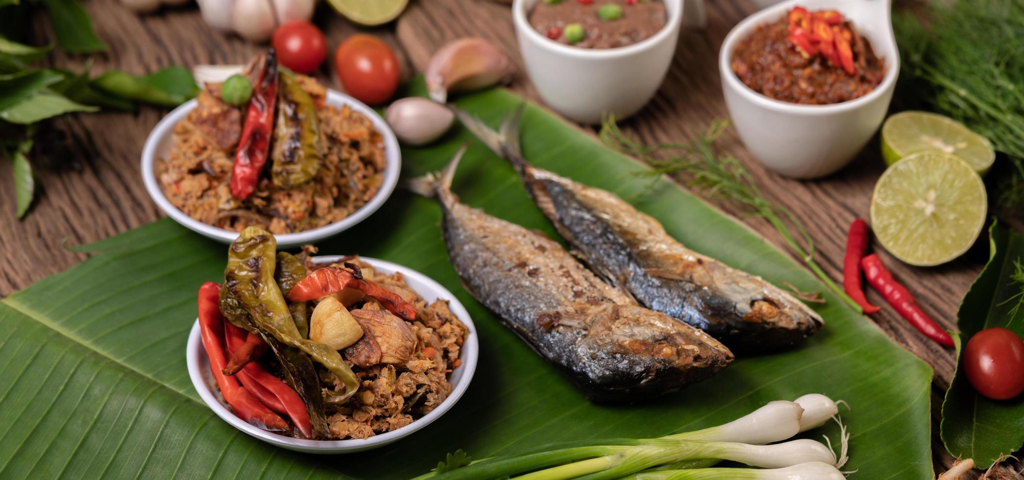 Shrimp paste and mackerel, fried on banana leaves with chili, tomato and garlic photo