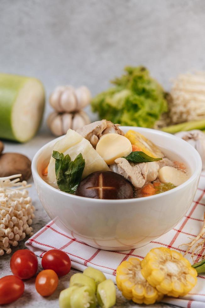 Chicken soup with corn, shiitake mushroom, enoki mushroom and carrot photo