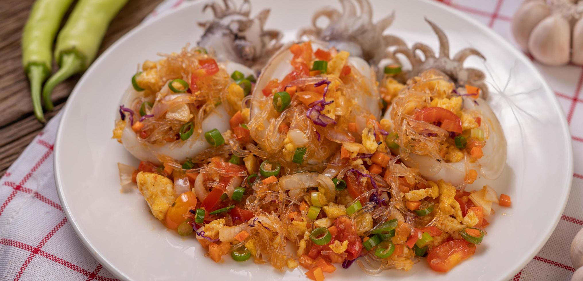 Stir fried glass noodles with squid on a red and white cloth photo