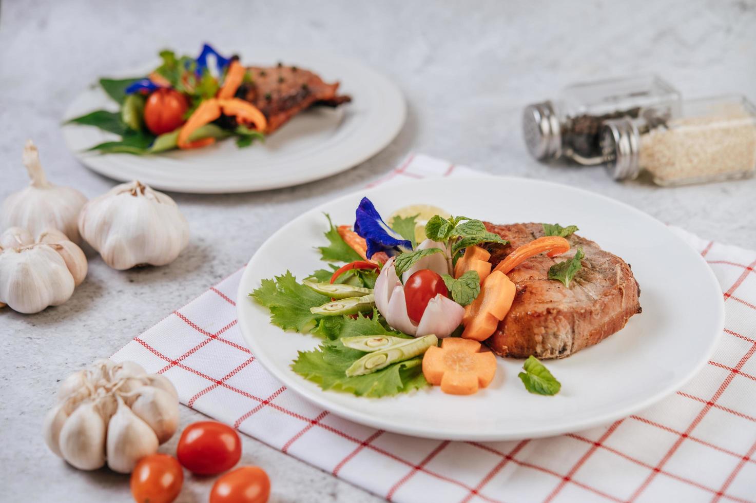 Pork steak with tomato, carrot, red onion, peppermint, butterfly pea flower and lime photo