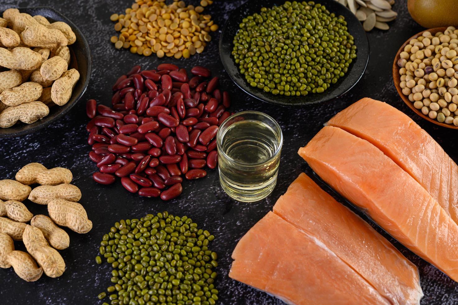 Legumes with salmon on a black cement background photo