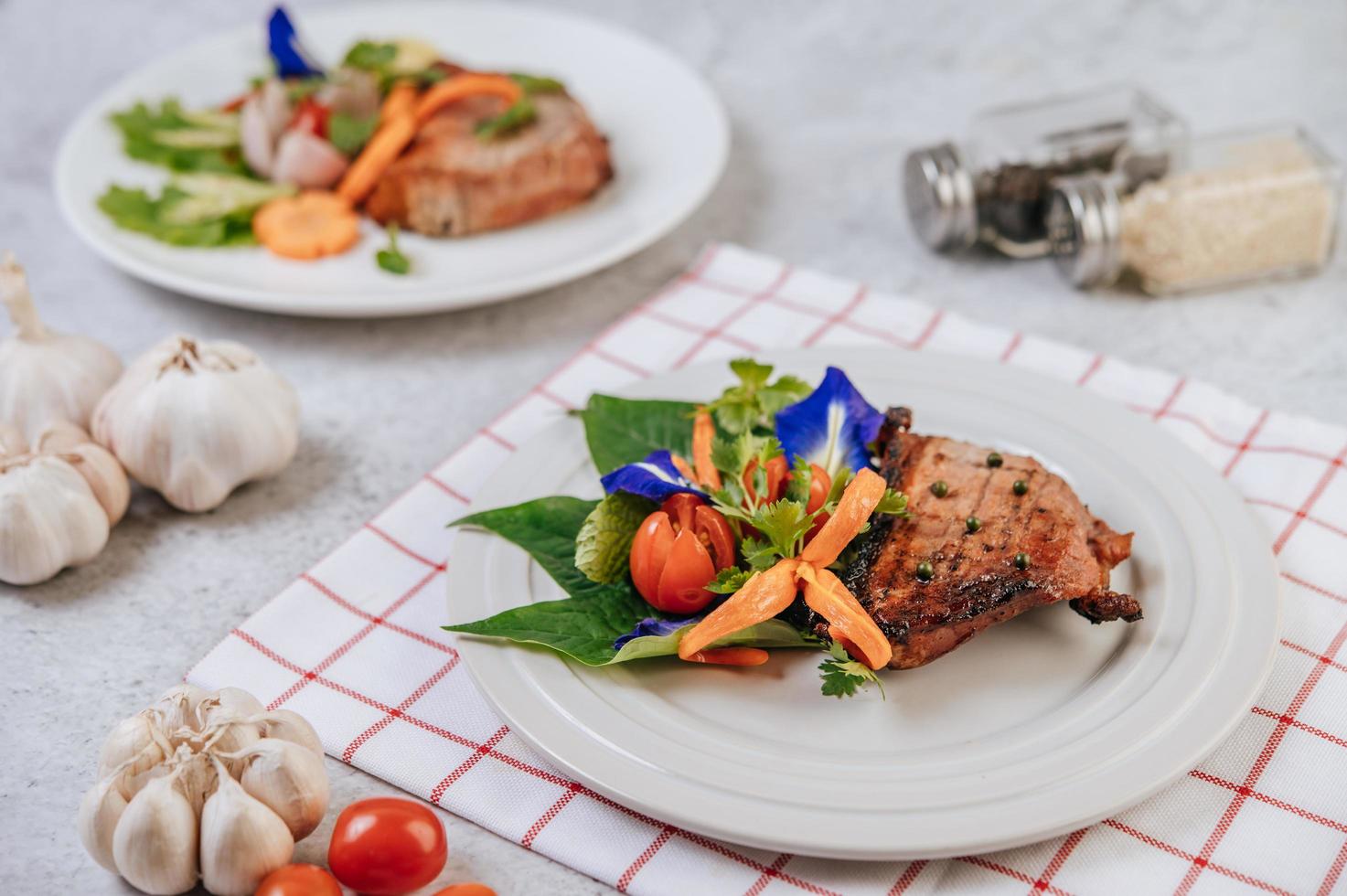 Pork steak with tomato, carrot, red onion, peppermint, butterfly pea flower and lime photo