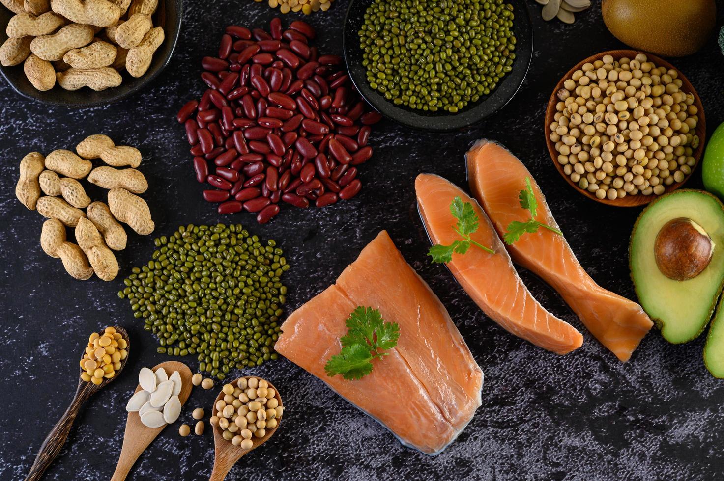 Legumes, fruit, and salmon on a black cement background photo