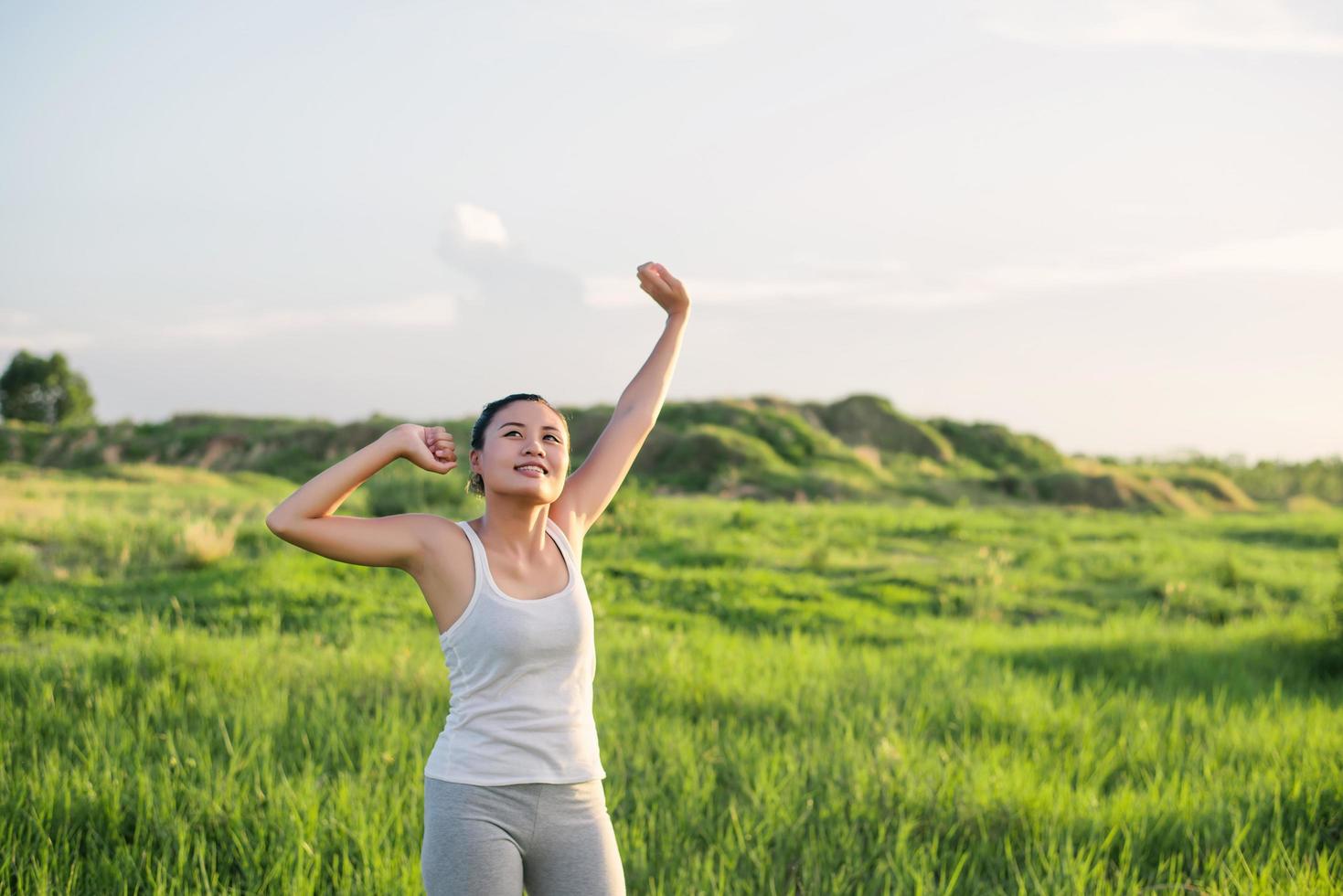 Happy beautiful woman with stretched arms in a meadow photo