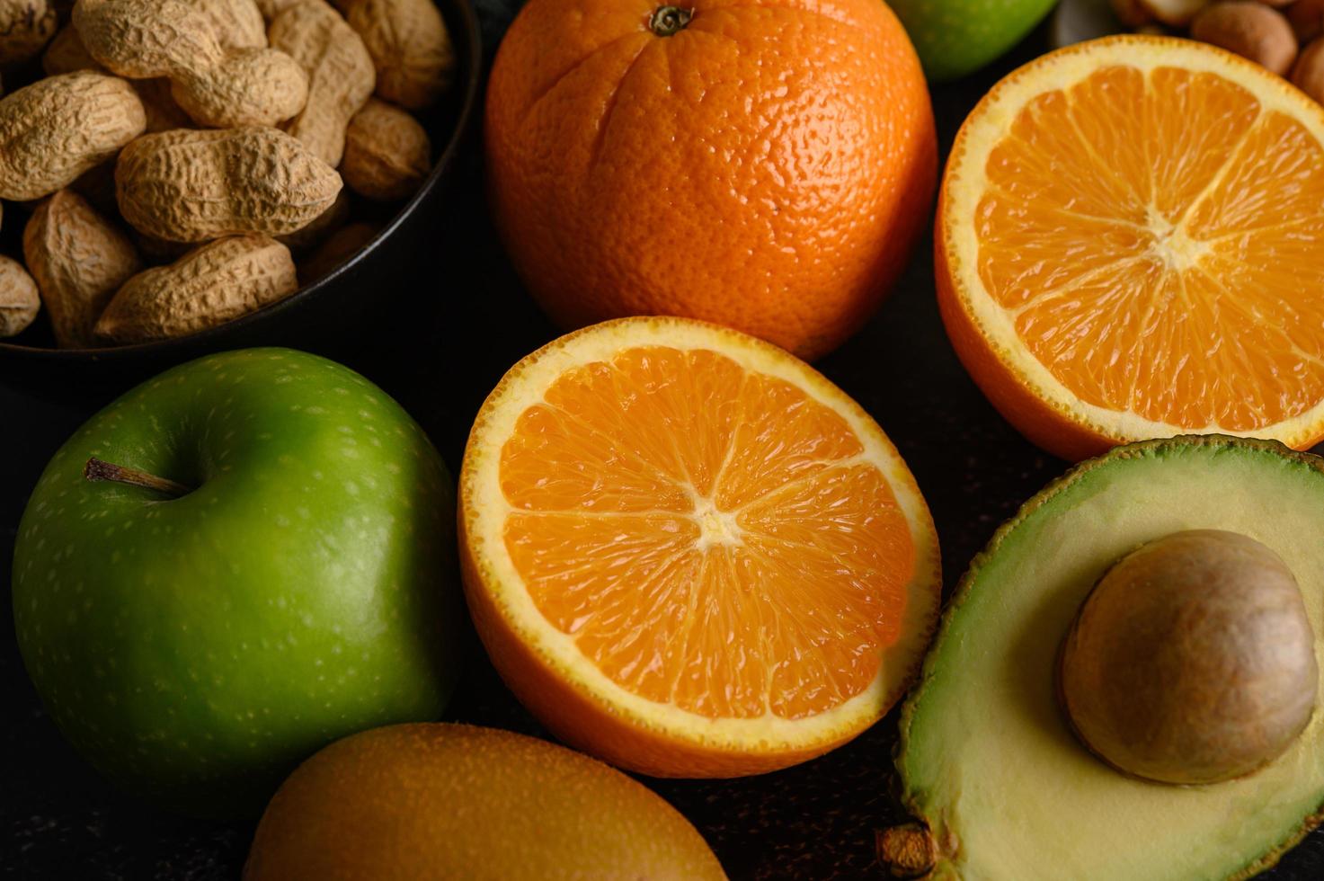 Rebanada de primer plano brillante de naranja fresca, manzana, kiwi y aguacate foto