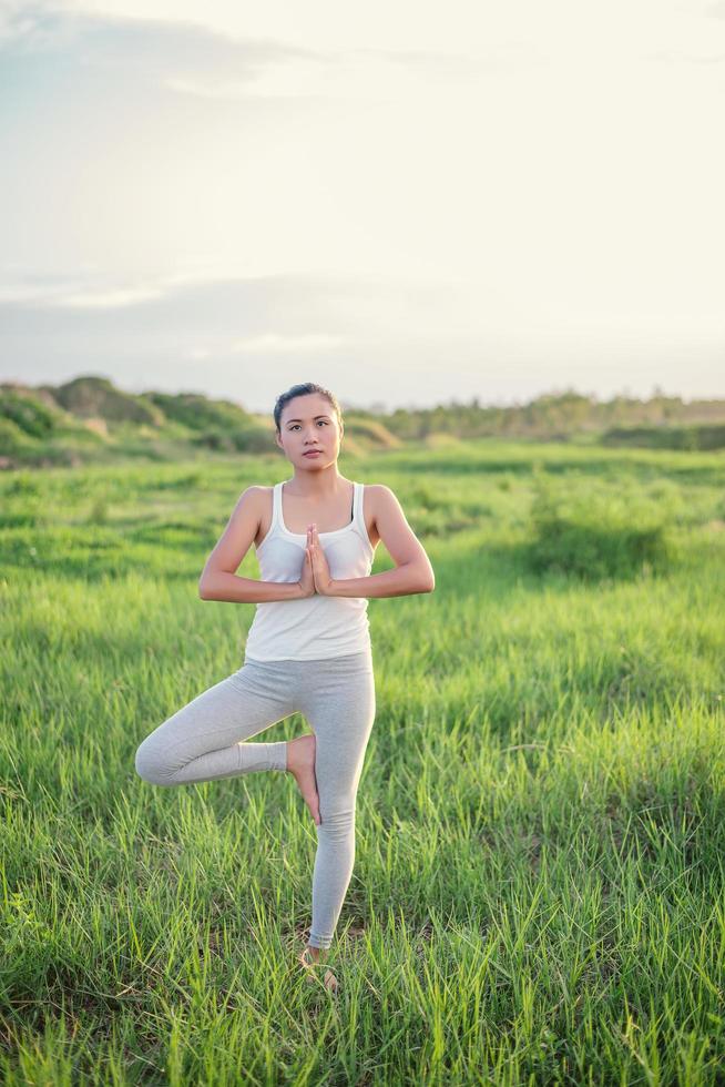 Beautiful yoga woman in sunny meadow photo